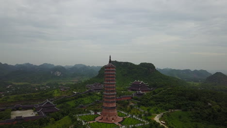 experience a captivating aerial orbit over the magnificent bai dinh pagoda in ninh binh, vietnam, showcasing its impressive scale, intricate architecture, and the stunning natural surroundings