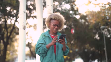 cheerful young woman using smartphone outdoors