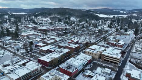 high aerial pull back of sprawling snow covered town in america