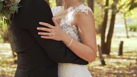 bride and groom embracing each other in autumn woods