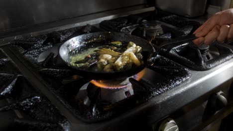 mussels tossed around in a cooking pan