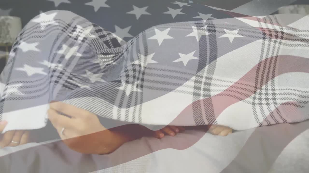 familia de raza mixta escondiéndose bajo una manta con nuestra bandera en primer plano