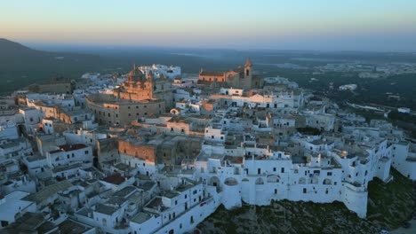 Toma-Panorámica-De-Drones-Aéreos-De-La-Histórica-Ciudad-Italiana-De-Ostuni-Durante-La-Puesta-De-Sol