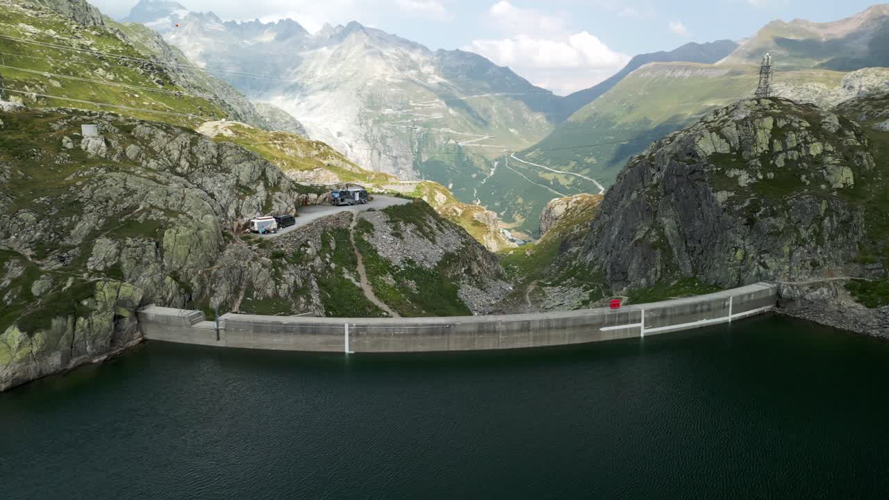 vista aérea panorámica del lago totensee y la presa del paso de grimsel en la temporada de verano con la cordillera en el fondo, suiza