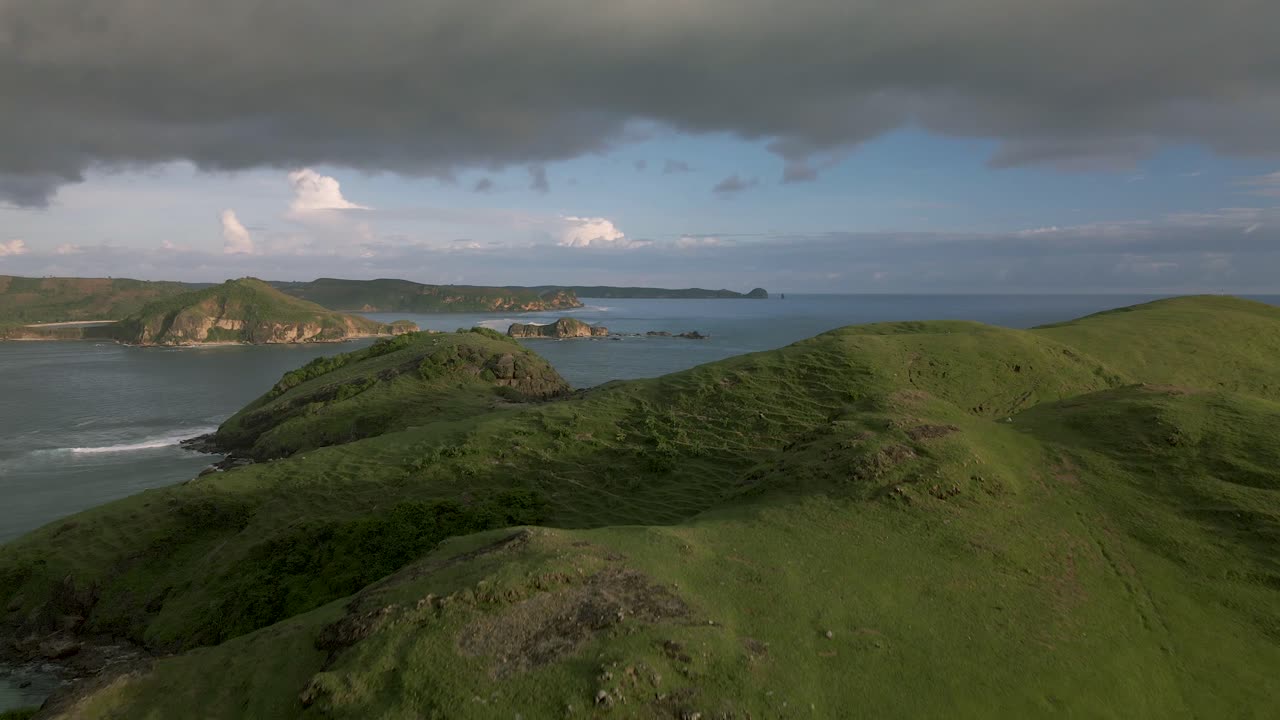 흐리고 화창한 날에 배낭을 메고 목가적인 푸른 언덕 풍경을 걷고 있는 남자
