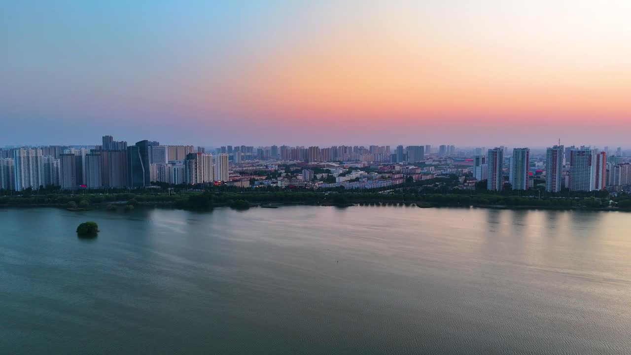 해가 지는 동안 린이 시의 강변을 지나가는 항공기