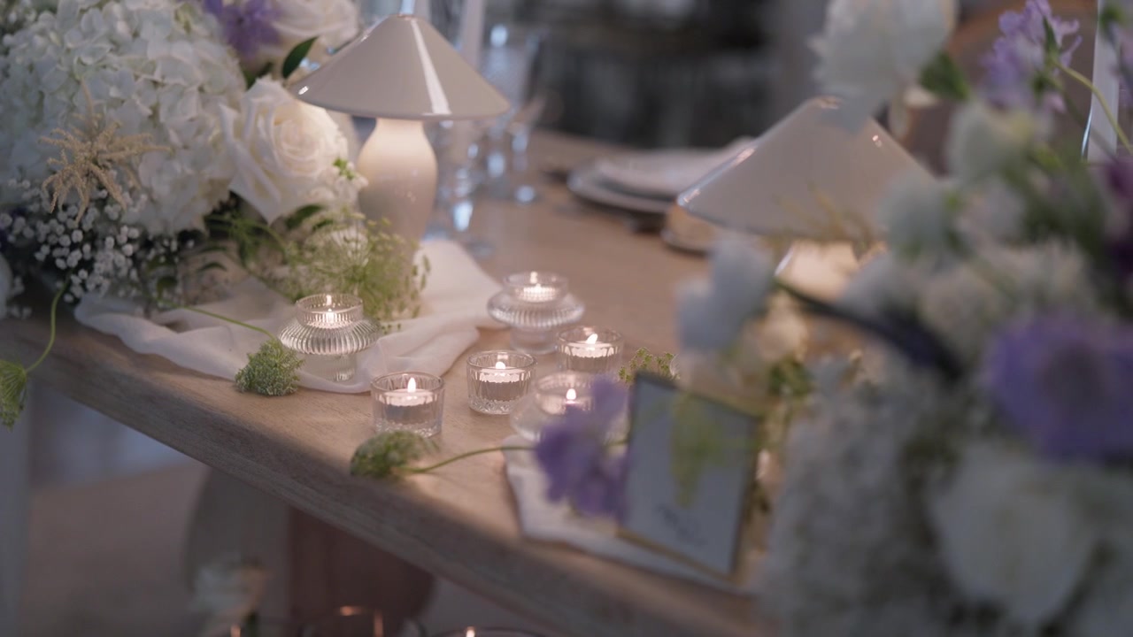 Wedding table with tealight candles cordless table lamps and white and lilac flowers