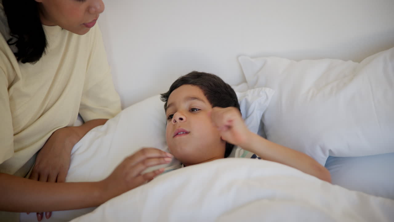 어머니가 아이의 체온을 확인하고 있습니다.