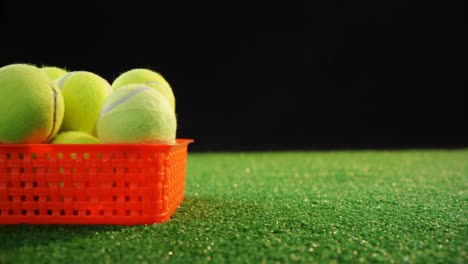 tennis balls in red basket at studio 4k