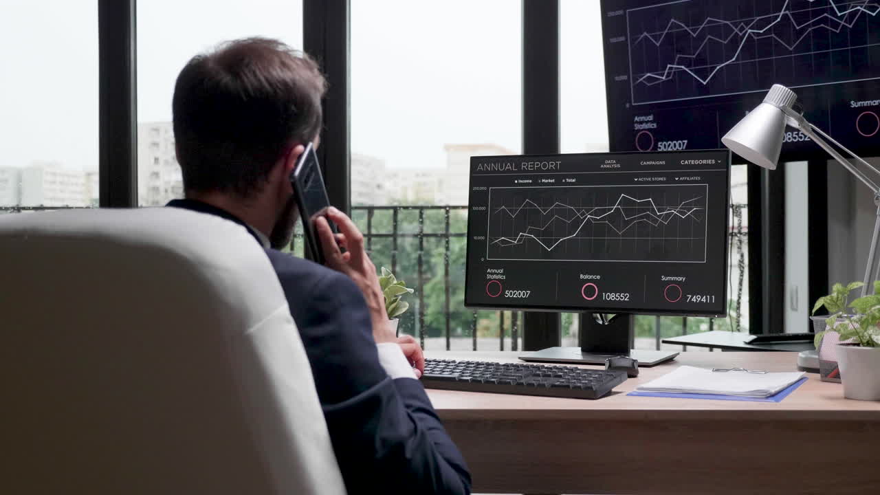 Businessman Analyzing Annual Report Data on Computer