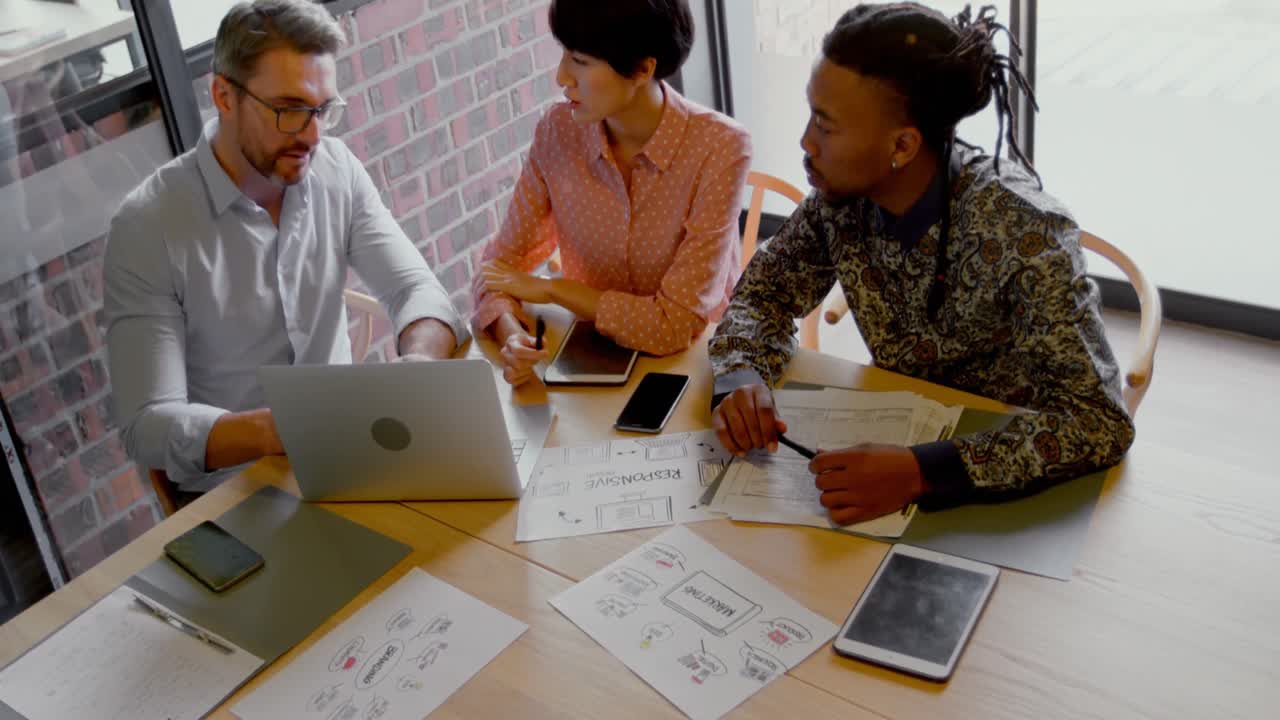 High angle view of business executives discussing over laptop 4k