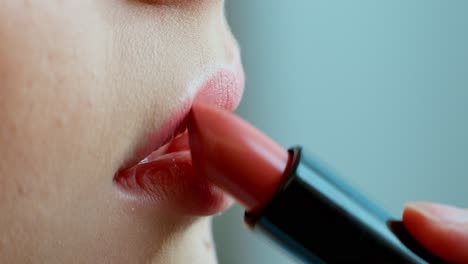 mujer aplicando lápiz labial