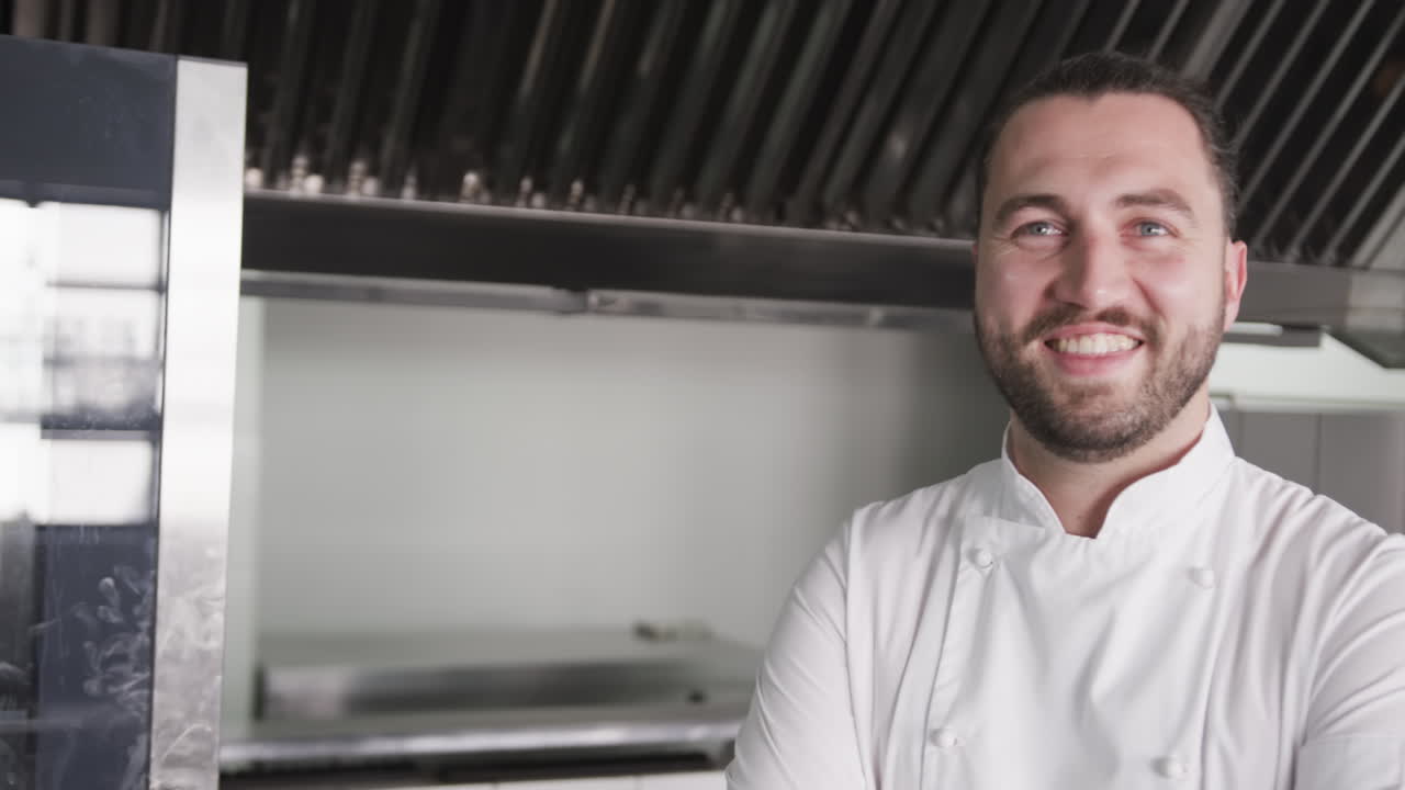 retrato de un feliz chef caucásico con barba sonriendo en la cocina, espacio de copia, cámara lenta