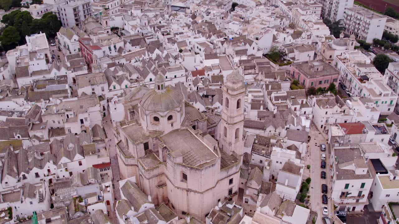 Borgo storico con facciate bianche sotto un cielo nuvoloso