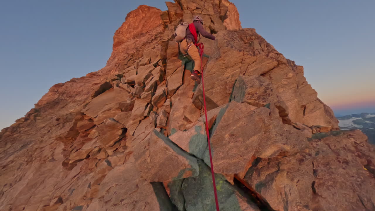 First-person POV of a climber ascending the iconic Matterhorn at sunrise on a crystal-clear bluebird day. Captured on GoPro for an immersive, realistic mountaineering experience above the clouds