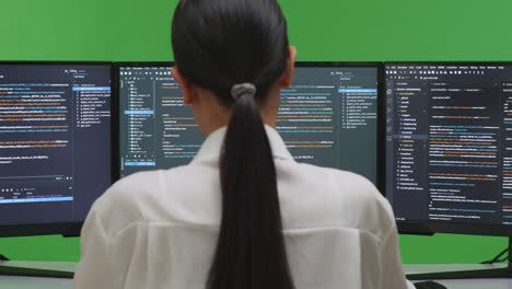 woman programmer in front of computer monotiors