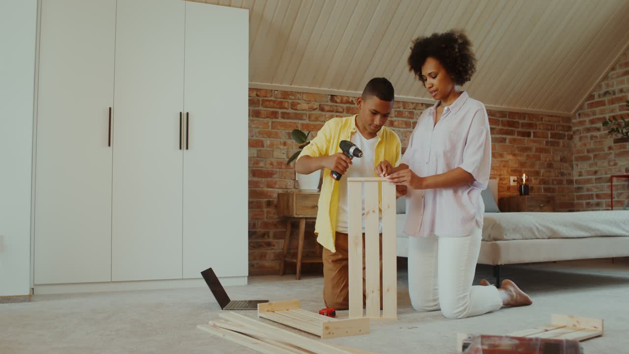 Moeder en zoon zetten houten krat in elkaar