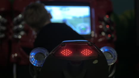 back view of boy riding toy motorcycle in indoors amusement park