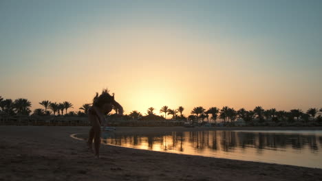 Schönes-Teenager-Mädchen,-Das-Am-Frühen-Morgen-Einen-Salto-Am-Meeresstrand-Zeigt.