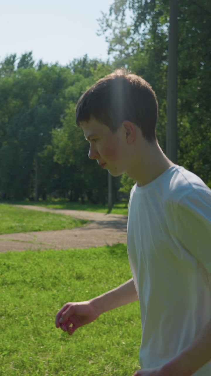 어린 소년은 활기차게 잔디을 가로질러 달려가며, 그의 할아버지는 뒷면에 골포스트를 가지고 근처에 서 있습니다.