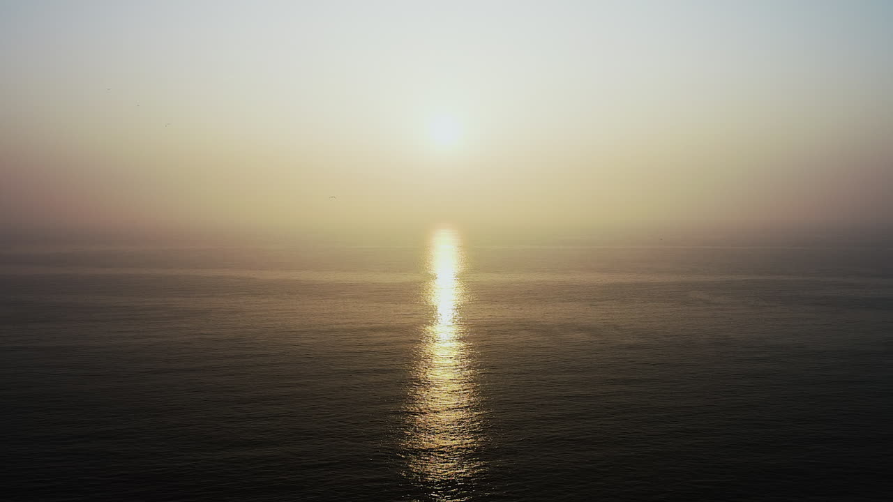 Sunset over the sea with a bird flying toward the sun. A tranquil, golden moment capturing nature’s calm and freedom.