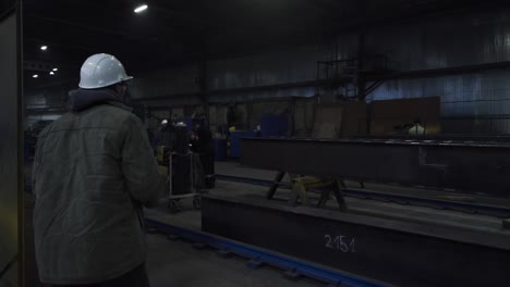 industrial workers inspecting steel beams in a factory