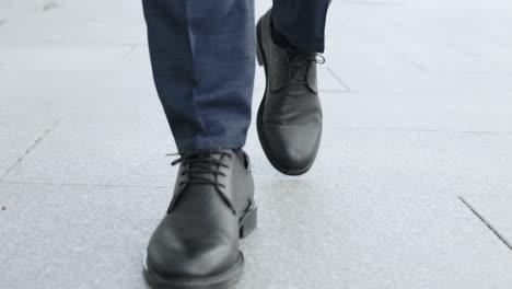 Businessman-legs-walking-on-city-street.Entrepreneur-wearing-black-leather-shoes