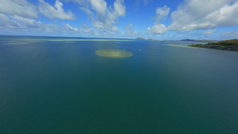 flying towards sandbar at kaneohe, oahu, coral and atolls visible from above, sailboats and blue waters below