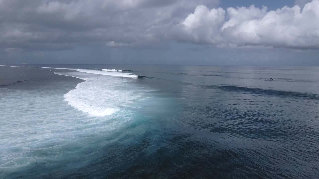 A calm and beautiful landscape aerial shot of waves peeling to the left above the reef