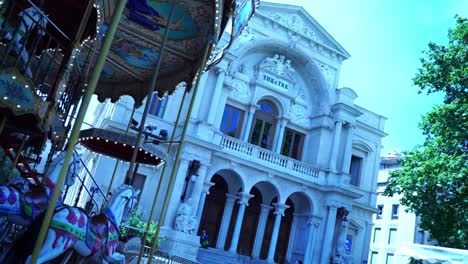 Wunderschönes-Historisches-Karussell-Dreht-Sich-Vor-Einem-Steinernen-Theatergebäude-In-Avignon,-Frankreich