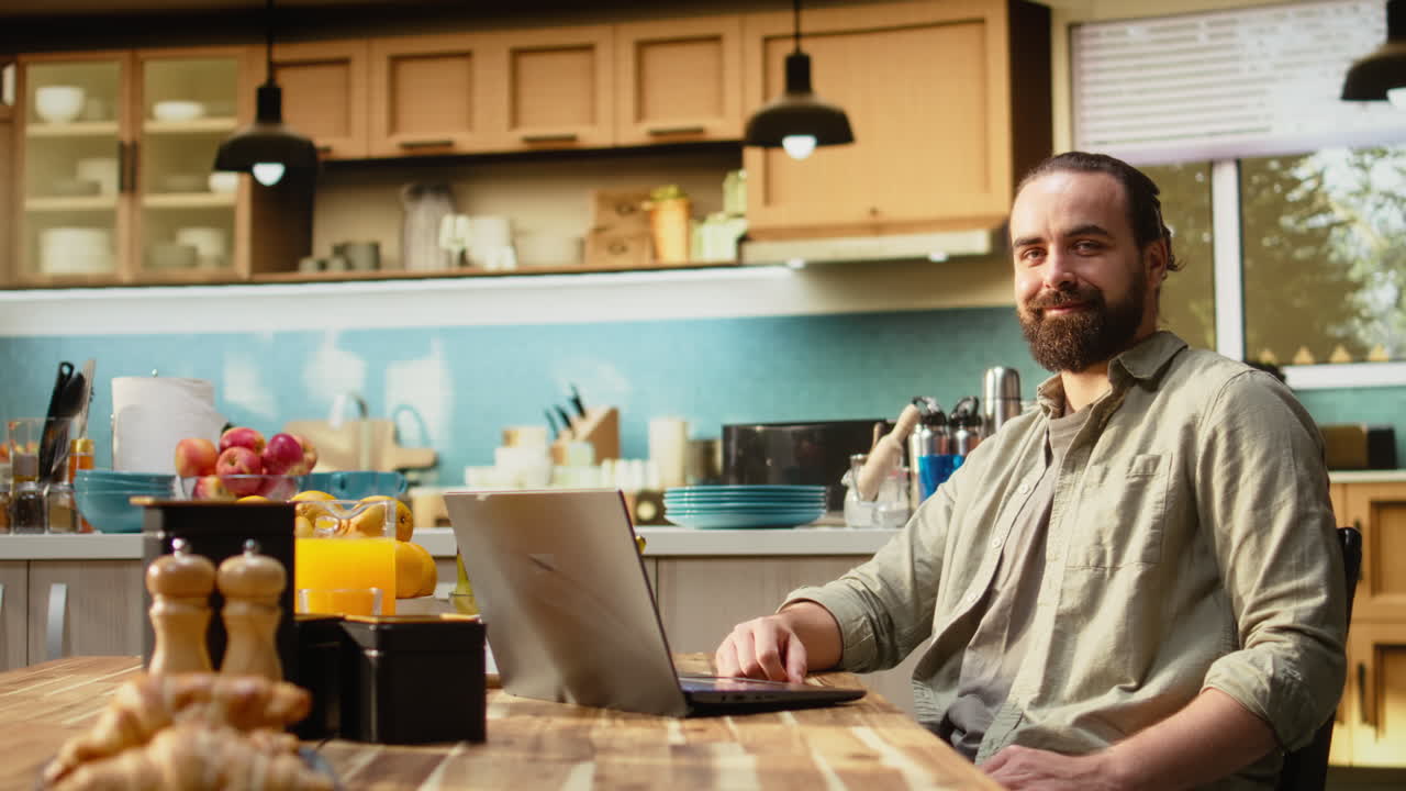 Portrait man freelancer, laptop at a breakfast table, working from home