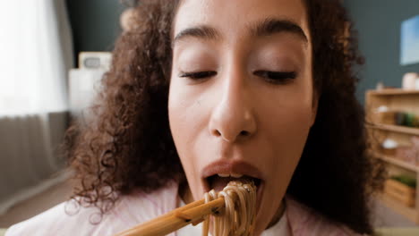 close-up of a person eating noodles with chopsticks