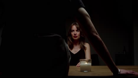 a woman recoils in fear as a man looms over the table, shouting at her - close up