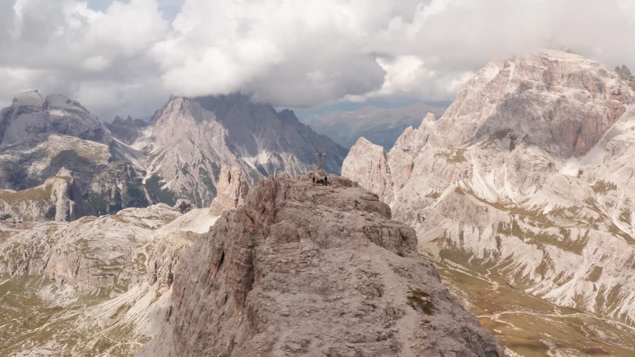 toma aérea en órbita de la cruz de la cumbre en la montaña monte paterno en dolomitas durante el día nublado