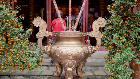 people offering incense at a temple in hanoi