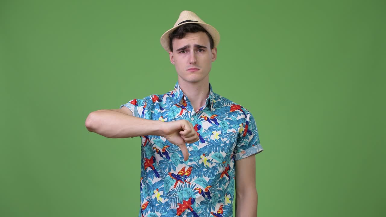 젊은 잘생긴 관광객이 엄지손가락을 내려놓고