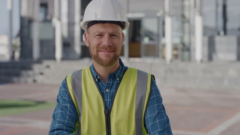 portrait young happy engineer man puts on safety helmet smiling arms crossed enjoying construction industry career wearing reflective clothing in city slow motion