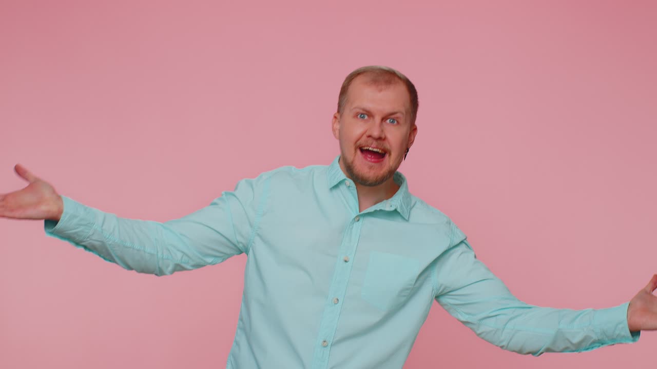 Bearded man smiling friendly at camera and waving hands gesturing hello or goodbye welcoming