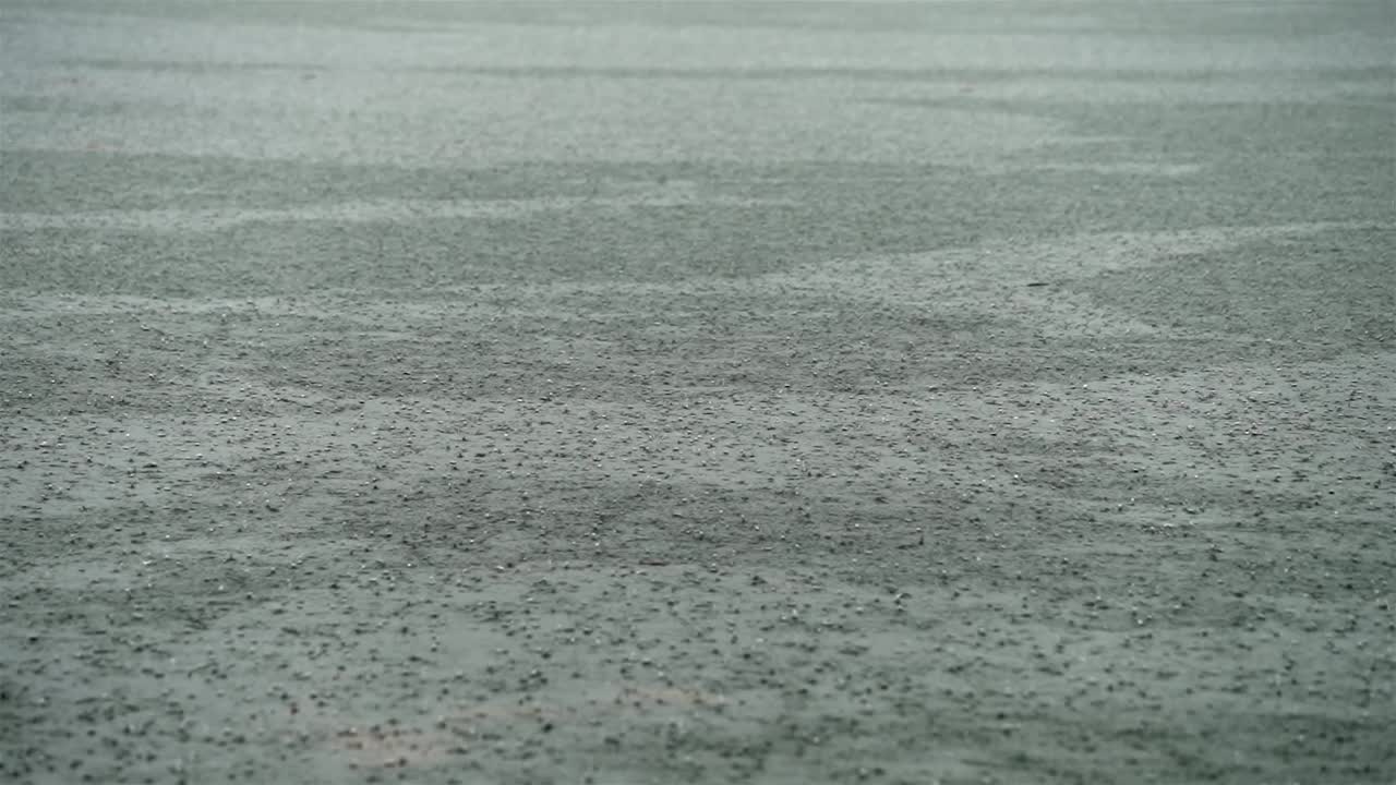 느린 움직임의 비가 질감있는 강물에 떨어지고, 추상적인 배경에 개별적인 방울이 떨어집니다.