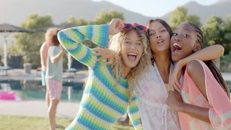 Portrait-of-happy-diverse-female-friends-embracing-and-having-fun-at-sunny-pool-party,-slow-motion