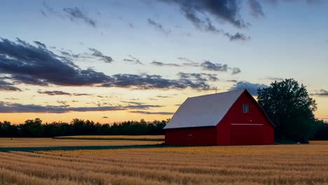 a red barn sits in the middle of a field at sunset