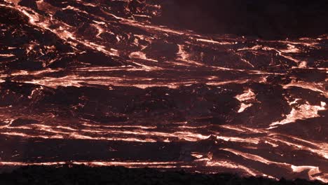 superficie de arrugas oscuras en el río de lava que fluye lentamente por la noche, campo volcánico activo