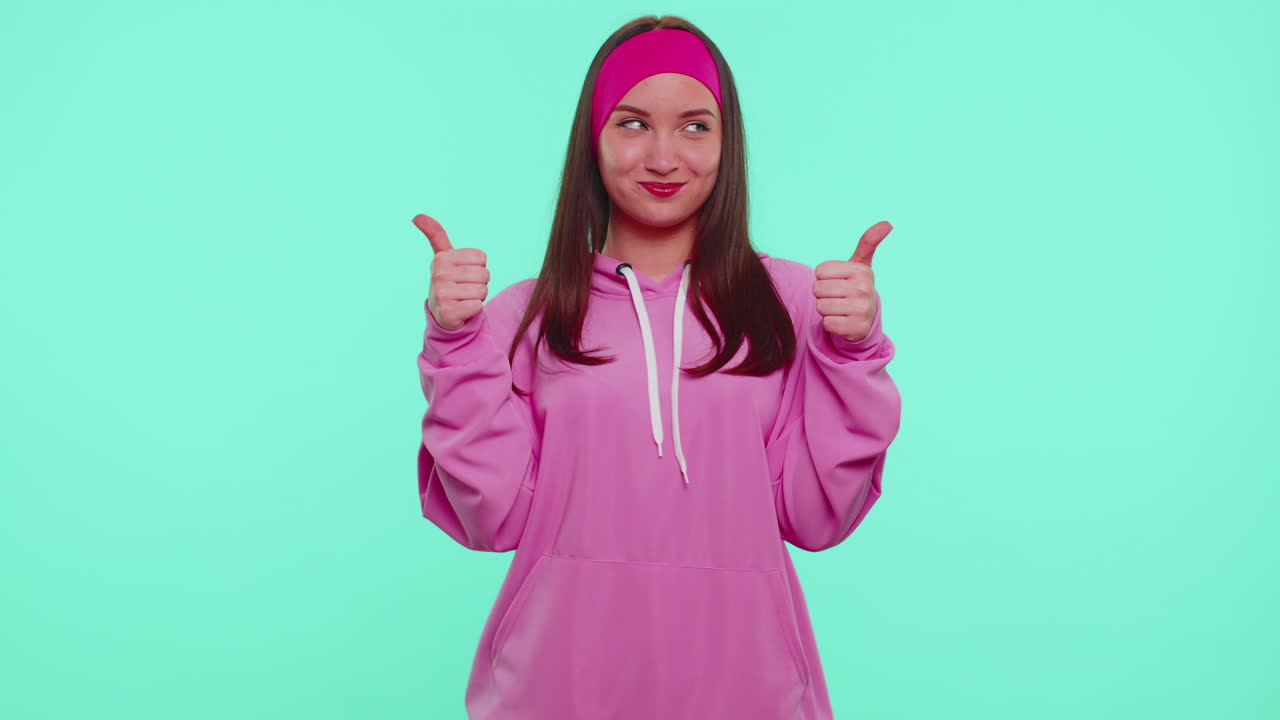 십대 소녀가 아래를 가리키고, 구독하라고 말하고, ok와 like를 제스처하고, 광고 장소를 보여주고