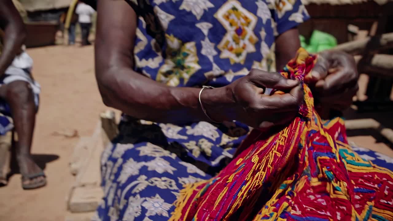 Close-up video capturing vibrant, colorful woven textiles in natural light, highlighting intricate
