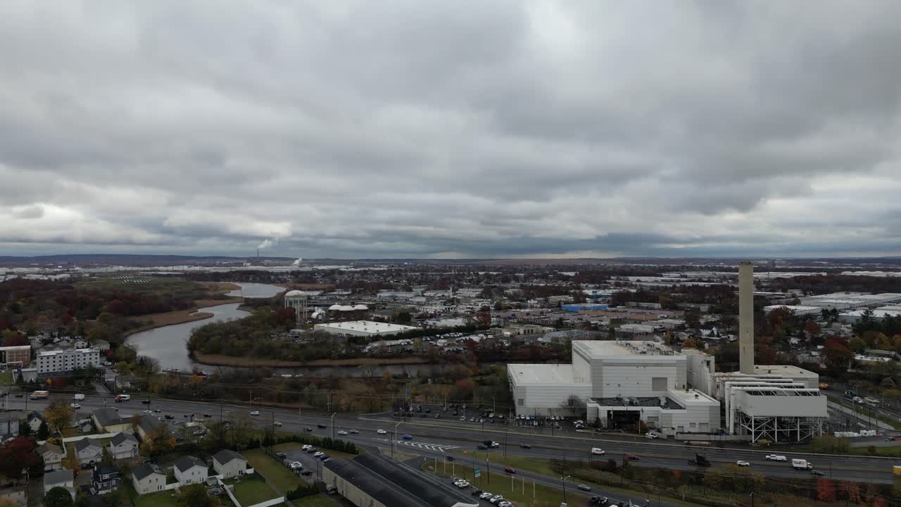 Aerial view of Rahway NJ showing residential homes, waterways, winding roads, tree lines, and nearby buildings captured from drone perspective on a cloudy day