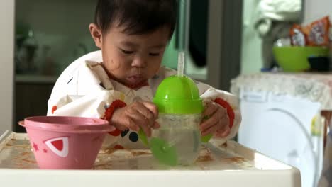 Mittlerer-Schuss-Von-Süßem-Asiatischem-Baby,-Das-Wasser-Aus-Der-Flasche-Trinkt