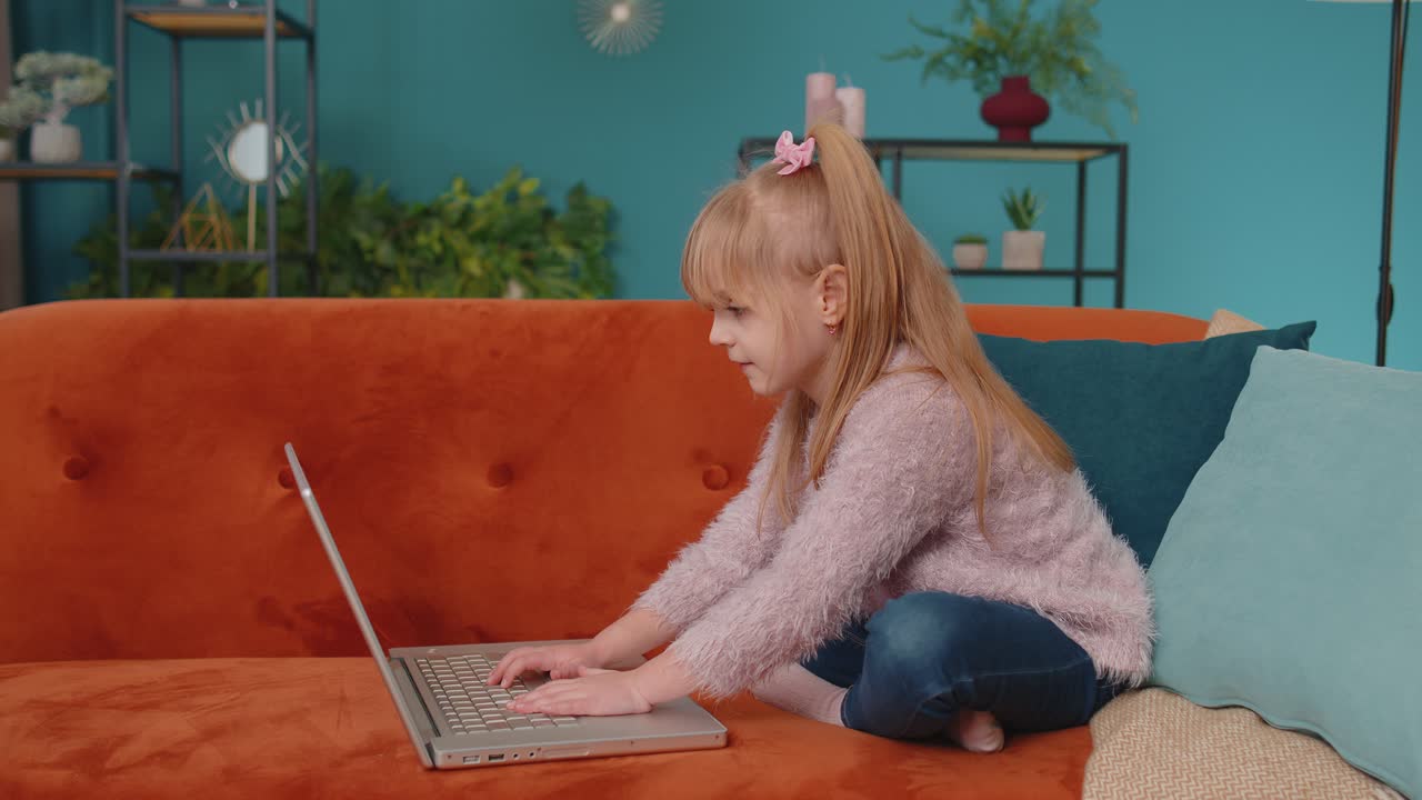 niña pequeña de escuela que usa una computadora portátil aprende a leer lecciones de educación en línea sola en casa