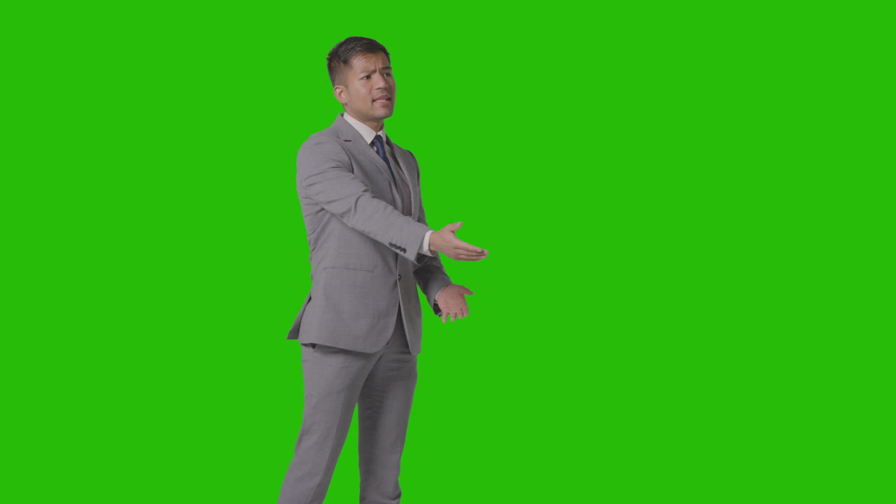 카메라에서 말하는 녹색 화면에 대해 소송을 제기하는 화난 사업가의 3/4 길이 샷