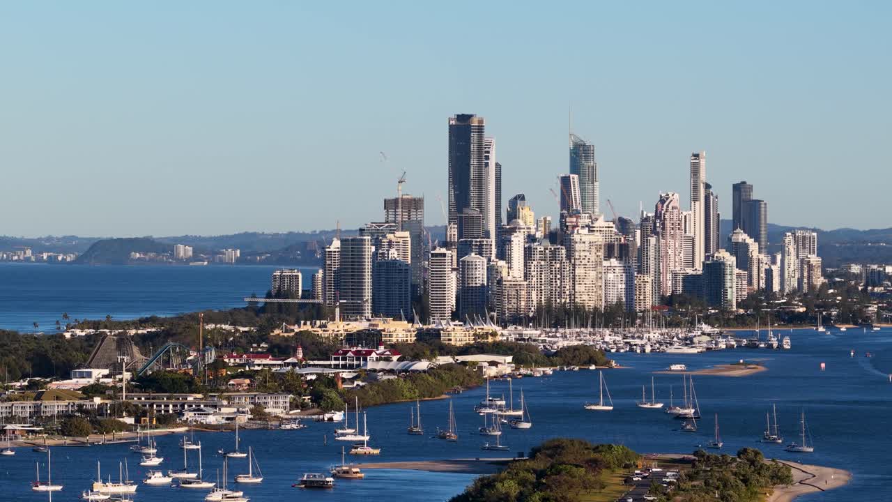 Drone captures panoramic view of Gold Coast skyline and waterways during sunset, highlighting urban landscape and vibrant colors