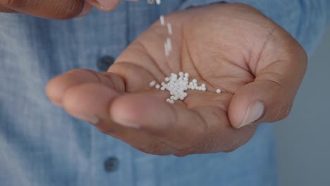 close-up of a hand holding homeopathic pellets